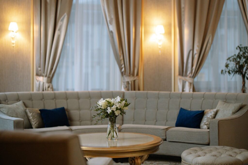 الجمال للأثاث ( ورشة ربيع احمد نعيم ) Luxurious lounge area featuring a plush sofa, chic curtains, and soft lighting.
